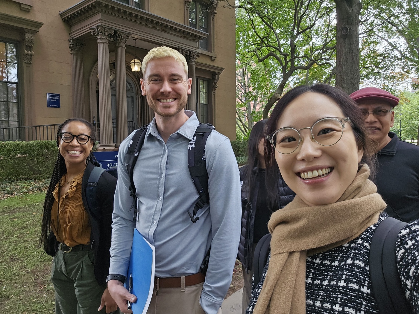 Small group of workshop participants smiling outdoors in front of a Yale building.