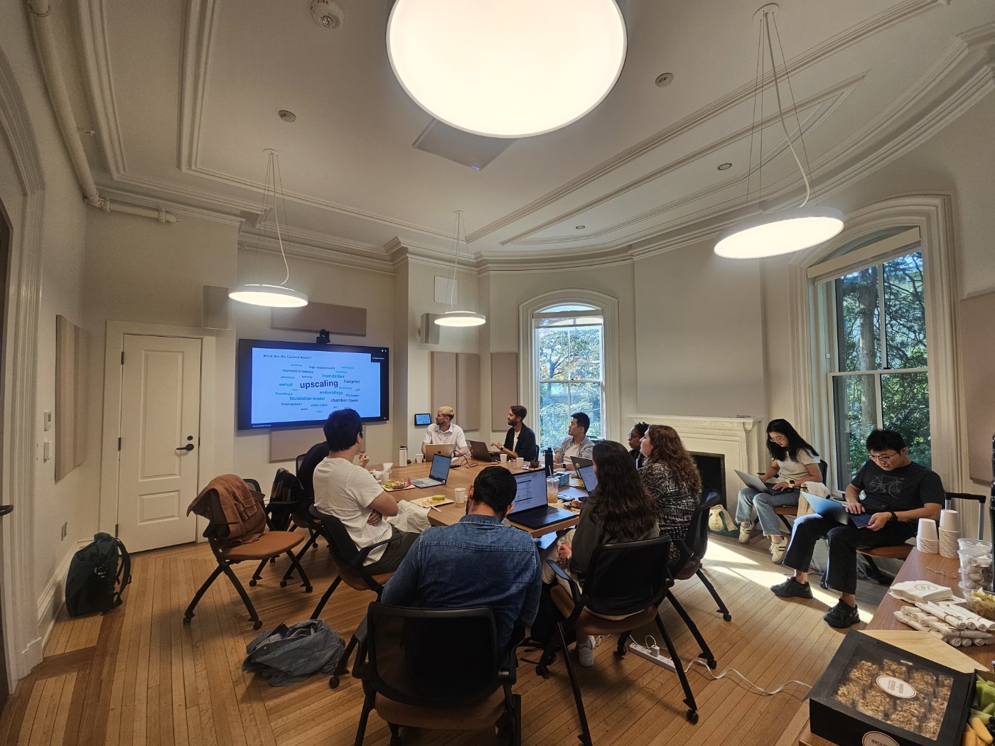 Researchers seated around a table with laptops during a workshop session at Yale.